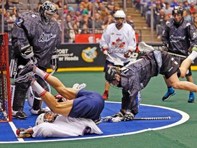 The Rock’s Damon Edwards gets dumped in front of Rush goaltender Aaron Bold on Sunday. (STAN BEHAL/Toronto Sun)