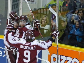 Peterborough Petes' Eric Cornel, centre, celebrates a goal with Greg Betzold and Josh MacDonald against the Kingston Frontenacs during Game 6 of OHL Eastern Conference quarter-final action on Sunday at the Memorial Centre in Peterborough. (Clifford Skarstedt/QMI Agency)