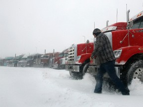 Transport truck driver Charles Fortin, of New Brunswick, leaves his truck at a truck stop in Enfield, Nova Scotia during a major storm March 26, 2014. A late season blizzard brought heavy snow and high winds blanket the province.  REUTERS/Darren Pittman