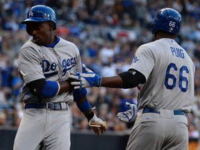 Los Angeles Dodgers second baseman Dee Gordon (9) celebrates with right fielder Yasiel Puig (66) after scoring in the fifth inning on the opening day baseball game against the San Diego Padres at Petco Park on Mar 30, 2014 at San Diego, CA, USA. (Christopher HanewinckeléUSA TODAY Sports)