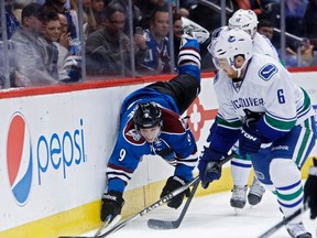 Colorado Avalanche center Matt Duchene (9) dives in pursuit of the puck against Vancouver Canucks defenseman Yannick Weber (6) during the second period at Pepsi Center on Mar 27, 2014 in Denver, CO, USA. (Chris Humphreys/USA TODAY Sports)