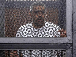 Al Jazeera journalist Mohamed Fahmy, a Canadian-Egyptian national, stands in a metal cage during his trial in a court in Cairo March 24, 2014. Fahmy is one of several Al Jazeera journalists Egypt put on trial on charges of aiding members of a "terrorist organisation", in a case that human rights groups say shows the authorities are trampling on freedom of expression. REUTERS/Al Youm Al Saabi Newspaper