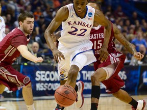 Kansas Jayhawks guard Andrew Wiggins (22) dribbles past Eastern Kentucky Colonels guard Isaac McGlone (5) and Orlando Williams (15) in the first half during the 2nd round of the 2014 NCAA Men's Basketball Championship at Scottrade Center on Mar 21, 2014 in St. Louis, MO, USA. (Jasen Vinlove/USA TODAY Sports)