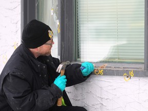 An officer with forensics identification unit works at the scene of a house shot at in the 500-block of Seven Oaks Avenue. (Kevin King/Winnipeg Sun)