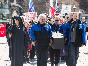 A group of protestors held a mock funeral procession, led by the "Grim Reeper", on Parliament Hill to rally as part of a National Day of Action. The Health Accord, an agreement between federal, provincial, and territorial governments that sets federal funding for health care expires on March 31. March 31, 2014. 
Errol McGihon/Ottawa Sun/QMI Agency