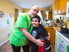 Tony Caprio embraces son Benjamin, 8, in the kitchen of their home in Oshawa Monday, March 31, 2014. The son called 911 when he saw his father having a seizure while making dinner on Sunday. (Ernest Doroszuk/Toronto Sun)