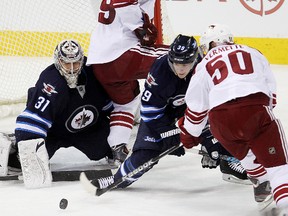 Winnipeg Jets goalie Ondrej Pavelec (left) and defenceman Toby Enstrom battle Phoenix Coyotes right winger Mikkel Bodeker (#89) and Phoenix Coyotes center Antoine Vermette for control of the puck during NHL hockey in Winnipeg, Man. on Monday, January 13, 2014.
(Brian Donogh/Winnipeg Sun/QMI Agency)