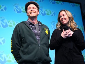 Tina Ferrone, of Kanata, picks up her cheque for $48 million at the OLG prize office in Toronto with her husband, Liam McGee, on Tuesday, April 1, 2014. (Dave Abel/Toronto Sun)