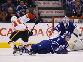 Maple Leafs captain Dion Phaneuf goes down to block a shot by Calgary’s Chad Billins in the first period Tuesday night. (Michael Peake/Toronto Sun)
