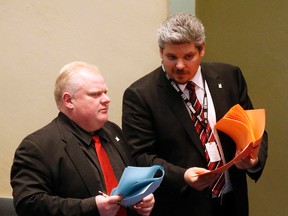 Chief of staff Dan Jacobs talks to the Mayor Rob Ford after he was the lone vote against honouring Canada's Olympic athletes and naming a street after Nelson Mandela on April 2, 2014. (Michael Peake/Toronto Sun)