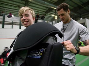 Sherwood Park bantam A Titans player Adam Regehr gets some assistance from Edmonton Rush goaltender Aaron Bold during Vimy Ridge Academy's lacrosse school at Edmonton Soccer Centre South on Wednesday. Seven members of the Edmonton Rush trained young lacrosse players during the two-day camp. (Ian Kucerak/Edmonton Sun)