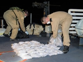HMCS Regina crew members catalogue and destroy 132 kg of seized heroin on the ship's quarterdeck off the coast of Africa on March 31, 2014. (Cpl Michael Bastien/MARPAC Imaging Services)