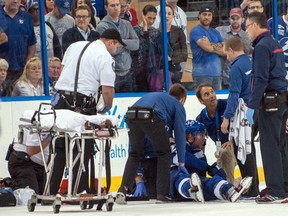 Tampa Bay Lightning defenceman Michael Kostka is treated by team staff after being knocked unconscious by Montreal Canadiens defenceman Douglas Murray  at Tampa Bay Times Forum. (Jeff Griffith/USA TODAY Sports)