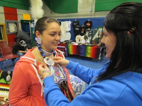 Traci Aquash, of Walpole Island, helps her daughter Shay-lynn Aquash, 15, prepare for the start of dancing Thursday at the 22nd annual Powwow at Lambton College. The annual celebration included dancers, arts and crafts,  and traditional drumming and singing. PAUL MORDEN/THE OBSERVER/QMI AGENCY