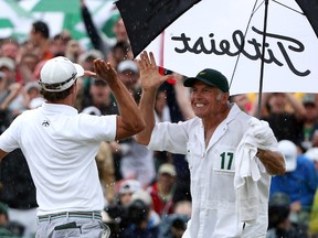 Adam Scott (left) celebrates with his caddie, Steve Williams, after his birdie on the 18th green got him into a playoff during the final round of the 2013 Masters at the Augusta National Golf Club on April 14, 2013 in Augusta, Georgia. (Ross Kinnaird/Getty Images/AFP)