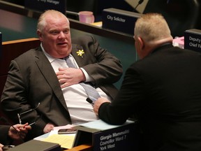 Mayor Rob Ford speaks with his brother, Councillor Doug Ford, in council chambers on Thursday. (CRAIG ROBERTSON/Toronto Sun)