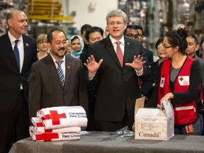 Canada's Prime Minister Stephen Harper talks during a demonstration of packing kitchen sets by the Canadian Red Cross that will be sent to the Philippines to help with the relief effort for Typhoon Haiyan, in Mississauga, April 3, 2014. (REUTERS/Mark Blinch)