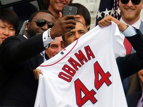 U.S. President Barack Obama poses with star player David Ortiz for a selfie as he welcomes the 2013 World Series Champion Boston Red Sox to the South Lawn of the White House in Washington, April 1, 2014. REUTERS/Larry Downing