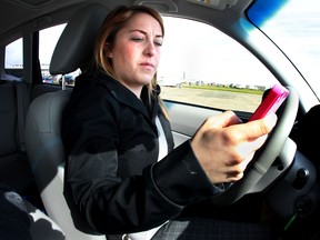 Edmonton Sun reporter Alison Salz writes a text while driving a obstacle course during a distracted driving news conference at Castro Raceway in Nisku, Alberta on May 10, 2013.  The Edmonton Police Service is partnering with the Alberta Motor Association (AMA), Edmonton Youth Council and Students for Cellphone-Free Driving to host a distracted driving challenge aimed at giving local high school students a close-up view on the dangers of distraction behind the wheel.  Perry Mah/Edmonton Sun/QMI Agency