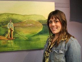 Sarnia artist Martha Finch, 22, stands inside Cheeky Monkey with one of her oil paintings that meld music imagery with natural landscapes. Jon Boat James shows the artwork from James Taylor's 1972 album transposed into a Vancouver Island background. It's one of five pieces Finch has on display starting this First Friday. TYLER KULA/ THE OBSERVER/ QMI AGENCY