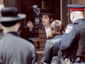 Nissan Malka motions for Chatham-Kent Children's Services workers to move away from the door to the Lev Tahor school where the ultra-orthodox Jewish community is living north of Chatham. Chatham Ontario, Wednesday April 02, 2014. (Diana Martin/Chatham Daily News/QMI Agency)