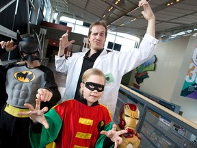 Dr. Yann Brouillette poses for a photo with Batman a.k.a Nathan Shaw, 10, Robin a.k.a. Alexis Shaw, 8, and Iron Man a.k.a. Andrew Shaw, 5, at the Telus World of Science on Thursday. Brouillette presented his talk, titled Comic Book Chemistry: Science vs Superheroes & Villains at the science centre.