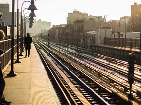 A commuter stands on a train platform waiting for a subway train during the morning commute in New York December 19, 2013. REUTERS/Lucas Jackson