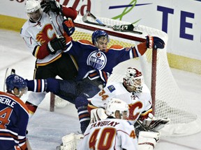 Edmonton's Taylor Hall falls into Calgary's Miikka Kiprusoff at Rexall Place during the Edmonton Oilers game in Edmonton on Thursday, October 7, 2010. (CODIE MCLACHLAN / EDMONTON SUN / FILE)