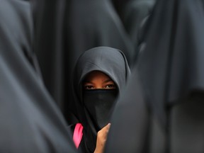 A girl wearing a hijab waits at the Shah Alam stadium during celebrations of Maulidur Rasul, or the birth of Prophet Muhammad, outside Kuala Lumpur January 14, 2014. REUTERS/Samsul Said (MALAYSIA - Tags: RELIGION)