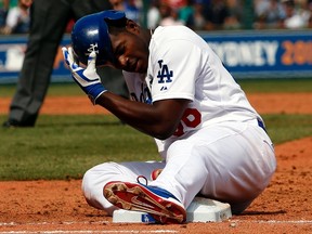 Los Angeles Dodgers batter Yasiel Puig reacts after being tagged out by Arizona Diamondbacks' Aaron Hill during the top of the third innings in their Major League Baseball game at the Sydney Cricket Ground March 23, 2014. (REUTERS/David Gray)
