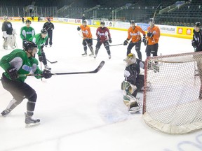 London Knights forward Christ Tierney, left, shoots the puck past goaltender Anthony Stolarz during a team hockey practice at Budweiser Gardens in London, Ontario on Thursday April 3, 2014.  (CRAIG GLOVER, The London Free Press)