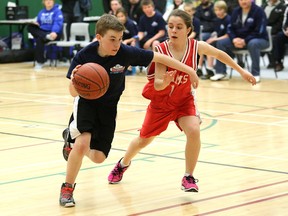 Carter Rouillard, left, of St. James, drives to the basket against Jordin Rancourt, of St. Francis, during action at the St. James-College Boreal Invitational at the college on Friday. JOHN LAPPA/THE SUDBURY STAR/QMI AGENCY
