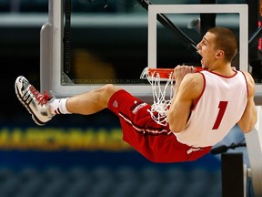 Wisconsin’s Ben Brust hangs on the rim as the Badgers practise ahead of the Final Four matches in Arlington yesterday. (AFP)