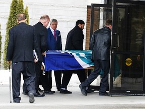 Pallbearers carry the casket, fitted with flag of the City of Ottawa, of former city councillor Jamie Fisher in to the Pinecrest Chapel on Friday April 4, 2014. 
Errol McGihon/Ottawa Sun/QMI Agency