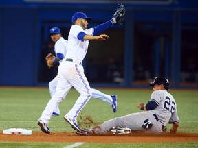 Ryan Goins of the Toronto Blue Jays misses the tag on Jacoby Ellsbury of the New York Yankees as he steals second during the season opener between the Toronto Blue Jays and the New York Yankees during MLB action at the Rogers Centre on Friday April 4, 2014. (Dave Abel/Toronto Sun/QMI Agency)