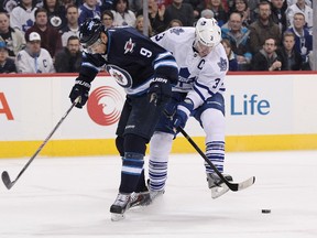 The Jets' Evander Kane battles for the puck with Leafs captain Dion Phaneuf on January 25, 2014 in Winnipeg at the MTS Centre. (Marianne Helm/Getty Images/AFP)