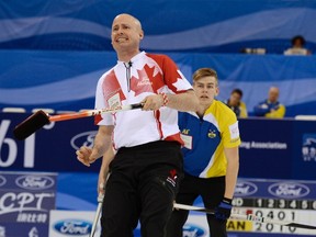 Canada's skip Kevin Koe (front) reacts as he watches a shot next to Sweden's lead Christoffer Sundgren in the semi-final of their World Men's Curling Championships in Beijing April 5, 2014. (REUTERS/China Daily)