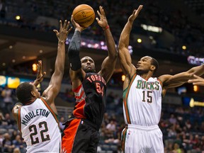 Toronto Raptors forward Patrick Patterson shoots the ball between Milwaukee Bucks forward Khris Middleton (22) and guard D.J. Stephens (15) on April 5. (Jeff Hanisch-USA TODAY Sports)