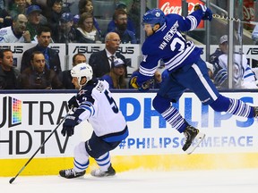 James van Riemsdyk of the Toronto Maple Leafs and Mark Stuart of the Winnipeg Jets on April 5. (Dave Abel, Toronto Sun)