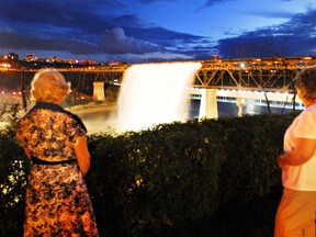 Edmonton, Alta Aug. 3, 2008. Bev Taylor, left, of Vancouver, BC, and Judith Lievers, right of Edmonton AB, enjoy the Great Divide waterfall on the High Level Bridge (109st) on for the festivities during the long weekend in Edmonton on August 3, 2008. Each minute, about 55,000 litres of water plunge from the bridge to the North Saskatchewan river 64 metres  below. Edmonton Sun/QMI Agency