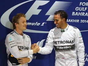 Mercedes AMG Petronas drivers Lewis Hamilton (R) celebrates on the podium with his teammate Nico Rosberg after winning the Formula One Bahrain Grand Prix at Sakhir circuit in Manama on April 6, 2014. (AFP
