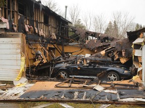 A Ford Mustang and another vehicle are visible covered in the rubble of a garage fire at 1376 Sunningdale Road in London, Ont. on Monday April 7, 2014. 
(Mike Hensen/The London Free Press/QMI Agency)