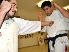 Shihan Paul Jackman (left) throws a punch towards student Chad Lum during practice April 2, 2014 in London, Ont. Lum is wearing the special protective equipment that makes Koshiki (contact) Karatedo unique. The Canadian Koshiki Karatedo Association announced that London will host the 2014 Koshiki Karatedo World Cup at Western University in June. CHRIS MONTANINI\LONDONER\QMI AGENCY