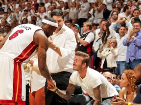LeBron James of the Miami Heat greets former MLS player David Beckham after playing against the Indiana Pacers in Game 7 of the Eastern Conference Finals during the 2013 NBA Playoffs on June 3, 2013 at American Airlines Arena in Miami, Florida. (AFP)