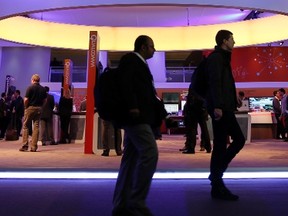 Visitors walk past the Qualcomm stand at the Mobile World Congress in Barcelona, Feb. 24, 2014. REUTERS/Albert Gea