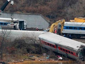 Workers stand near cranes at the Metro-North train derailment site in the Bronx borough of New York December 2, 2013.   REUTERS/Shannon Stapleton