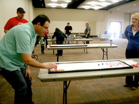 Greg Miller tries his luck at tabletop curling with Judy Miller being the spectator at the Jeffrey Zorn Memorial Bonspiel  at the Mackenzie Conference Centre on Apr. 5 where the community enjoyed various activities and bid on goodies raising $22K, which will go to the Make-A-Wish Foundation.