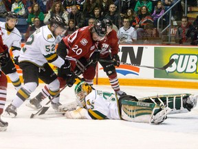 London Knights goaltender Jake Patterson covers up the puck as Knights defenceman Alex Basso and Guelph Storm forward Justin Auger move in during game 1 of the OHL Western Conference semi-finals at the Sleeman Centre in Guelph, Ontario on Friday April 4, 2014. (CRAIG GLOVER/The London Free Press/QMI Agency)