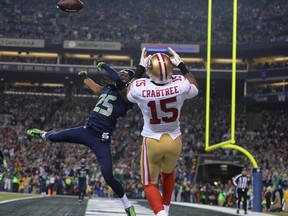 Seattle Seahawks cornerback Richard Sherman (25) tips the ball against San Francisco 49ers wide receiver Michael Crabtree (15) for an interception by Seahawks outside linebacker Malcolm Smith (not pictured) during the fourth quarter of the 2013 NFC Championship football game at CenturyLink Field. (Kyle Terada-USA TODAY Sports)