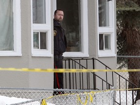 A Winnipeg Police officer peers from the front of a house in the 600 block of Manitoba Avenue in Winnipeg, Man. after a male was shot Monday April 07, 2014.
Brian Donogh/Winnipeg Sun/QMI Agency
